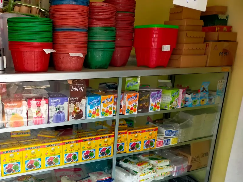 Keranjang plastik warna-warni dan dus kue bertumpuk